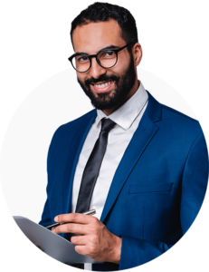 A photo of a professional looking man in a blazer, smiling at the camera with a tablet in his hand.